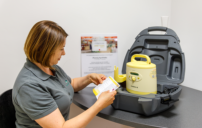 Eine Mitarbeiterin der Pluwig Apotheke sitzt im extra Raum und ließ die Gebrauchsanweisung eines Gerätes.