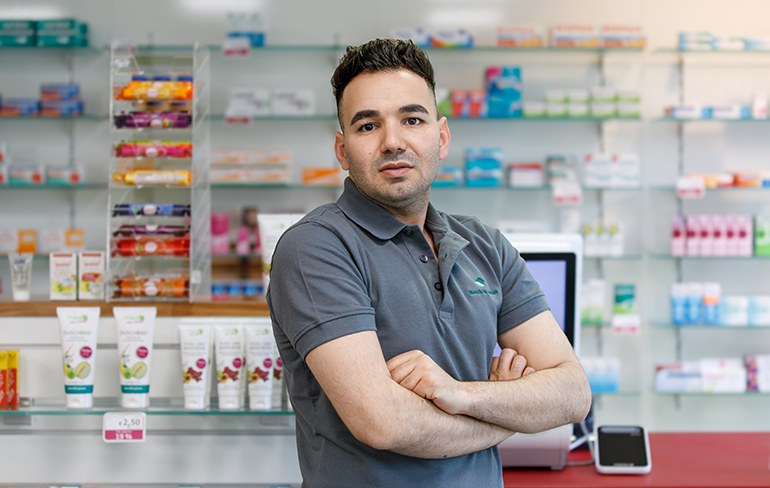 Der Inhaber der Pluwig Apotheke steht vor dem Medikamentenregal in der Apotheke.