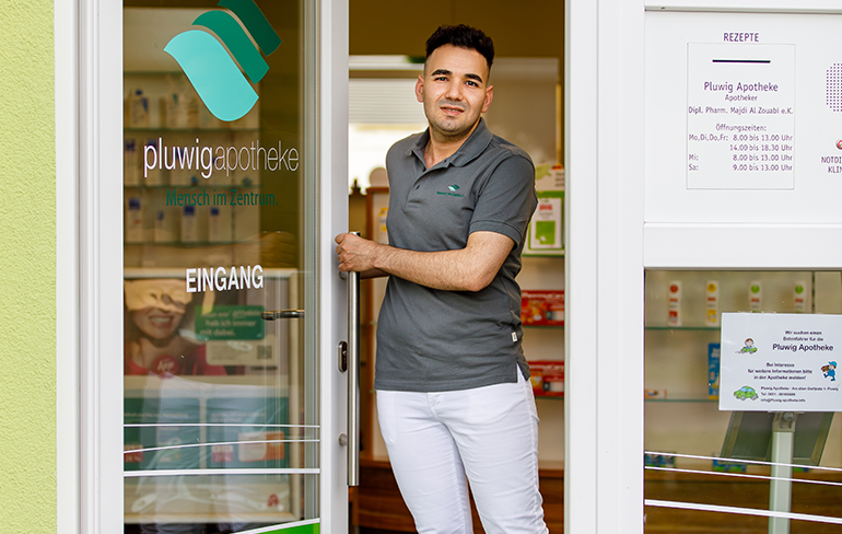 Der Inhaber der Pluwig Apotheke steht in der Tür der Apotheke.