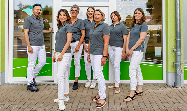 Apothekenteam steht vor der Pluwig Apotheke, alle tragen ein Shirt der Pluwig Apotheke in Pluwig.